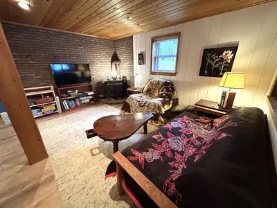 a living room with a couch and a table at Lakefront Cabin Pvt Beach and Dock - Sunset Marina in Arrowhead Lake