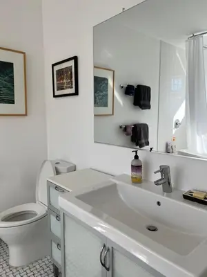 a white bathroom with a sink and a toilet at Modern loft style 2bed 2bath minutes to Times Square in West New York