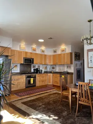 a kitchen with wooden cabinets and a table and chairs at Modern loft style 2bed 2bath minutes to Times Square in West New York