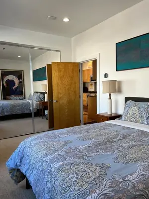 a bedroom with a large bed with a blue blanket at Modern loft style 2bed 2bath minutes to Times Square in West New York