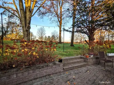 a garden with a table and chairs in a park at Cromwell Manor Inn in Cornwall-on-Hudson