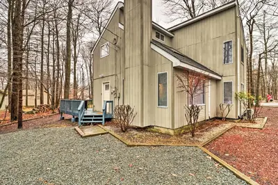 a house with a blue bench in front of it at Family-Friendly Tobyhanna Home with Game Room! in Tobyhanna