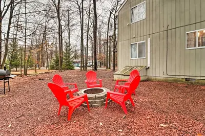 a group of red chairs sitting around a fire pit at Family-Friendly Tobyhanna Home with Game Room! in Tobyhanna