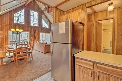 a kitchen with a refrigerator and a dining room at Lake Harmony Access Home with Game Room and Fire Pit! in Lake Harmony