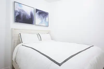 a bedroom with a white bed with three pictures on the wall at 454-3W PRIME location 2BR Newly Furnished sleeps 5 in New York