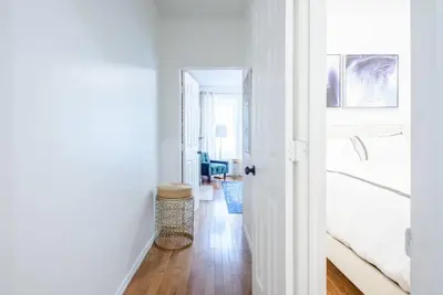 a white room with a bedroom with a bed and a hallway at 454-3W PRIME location 2BR Newly Furnished sleeps 5 in New York
