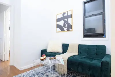 a living room with a green couch and a table at 454-3W PRIME location 2BR Newly Furnished sleeps 5 in New York