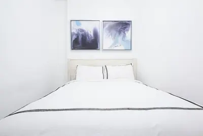 a bedroom with a white bed with three pictures on the wall at 454-3W PRIME location 2BR Newly Furnished sleeps 5 in New York