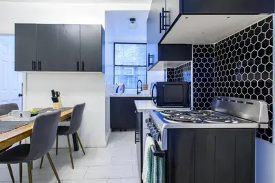 a kitchen with a stove and a table with chairs at 454-3W PRIME location 2BR Newly Furnished sleeps 5 in New York