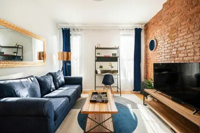 a living room with a blue couch and a brick wall at 454-4R New 2BR prime midtown Best value Sleeps 5 in New York
