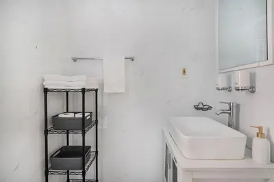 a bathroom with a sink and a shelf with towels at 454-4R New 2BR prime midtown Best value Sleeps 5 in New York
