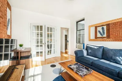 a living room with a blue couch and a brick wall at 454-4R New 2BR prime midtown Best value Sleeps 5 in New York