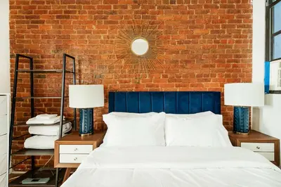 a bedroom with a brick wall and a bed with two lamps at 454-4R New 2BR prime midtown Best value Sleeps 5 in New York
