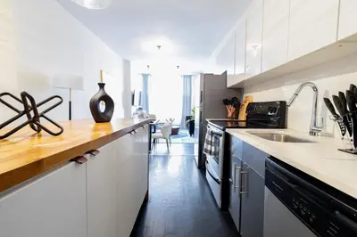 a white kitchen with a sink and a counter top at E10-1 Designer East Village Townhouse 1BR in New York