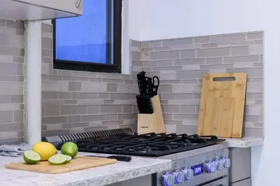 a kitchen counter with a stove top with a cutting board at 428-2W Newly Furnished Prime Location 2BR Sleeps 5 in New York