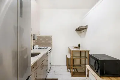 a white kitchen with a sink and a stove at 428-2W Newly Furnished Prime Location 2BR Sleeps 5 in New York