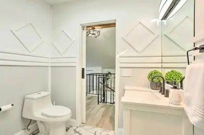 a white bathroom with a toilet and a sink at Hike, Ski and Golf Mtn-View Codo in Vernon Township in Vernon Township