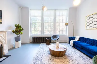 a living room with a blue couch and a coffee table at E10-2 Designer East Village Townhouse 1BR W D in New York