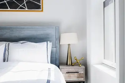 a bedroom with a bed and a lamp on a night stand at E10-2 Designer East Village Townhouse 1BR W D in New York