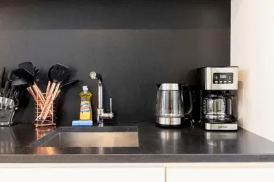a kitchen counter with a coffeemaker and a coffee maker at E10-2 Designer East Village Townhouse 1BR W D in New York