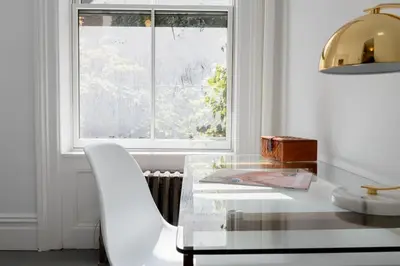 a dining room with a glass table and a white chair at E10-2 Designer East Village Townhouse 1BR W D in New York