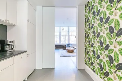 a kitchen with white cabinets and a green wall at E10-2 Designer East Village Townhouse 1BR W D in New York
