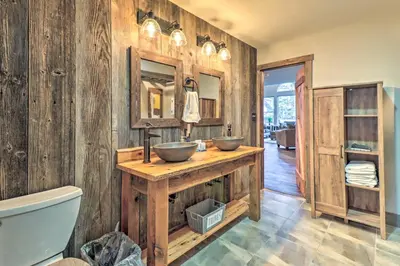 a bathroom with two sinks on a wooden wall at Hot Tub, Beach Access Albrightsville Retreat! in Albrightsville