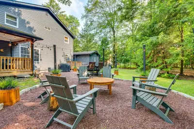 a patio with chairs and a table and a house at Hot Tub, Beach Access Albrightsville Retreat! in Albrightsville