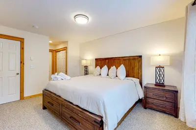 a bedroom with a large bed with a wooden headboard at Casa Lontano in Tannersville