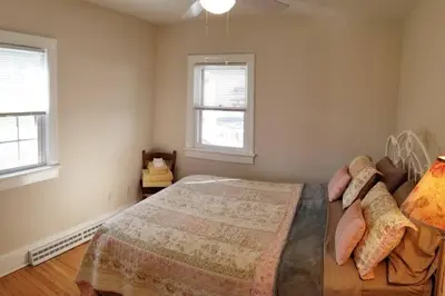 a bedroom with a bed and two windows at Private Lakeview Cottage and 2 Farmhouse Apartments near Rt 80 easy to NYC in Blairstown