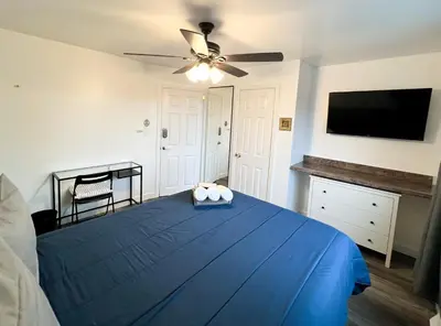 a bedroom with a blue bed with a ceiling fan at Sunny Queen bedroom feel like home!! in Englewood