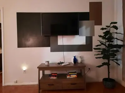 a living room with a tv and a table with a plant at Pet Friendly Apartment minutes from NYC! in West New York