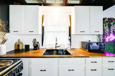 a kitchen with white cabinets and a sink and a microwave at Pet-Friendly Cabin in Pocono Lake! in Pocono Lake
