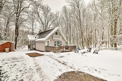 a small house in the snow in the woods at Pet-Friendly Cabin in Pocono Lake! in Pocono Lake