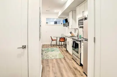 a kitchen with white cabinets and a table with chairs at Classy Philly Apartment 2 Mi to Downtown! in Philadelphia