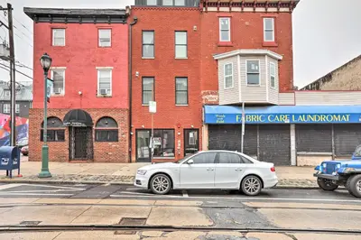 a white car parked in front of a brick building at Classy Philly Apartment 2 Mi to Downtown! in Philadelphia