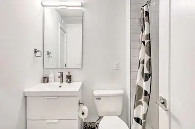 a bathroom with a toilet and a sink and a mirror at Classy Philly Apartment 2 Mi to Downtown! in Philadelphia