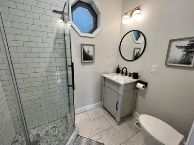 a bathroom with a shower and a sink and a toilet at Cozy Cabin on the Lake w/ HotTub in Hopatcong