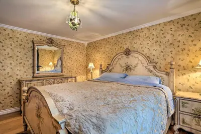 a bedroom with a large bed and a mirror at 1 Mi to Lake Wallenpaupack Spacious Poconos Villa in Hawley