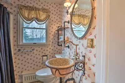 a bathroom with a toilet and a sink and mirrors at 1 Mi to Lake Wallenpaupack Spacious Poconos Villa in Hawley