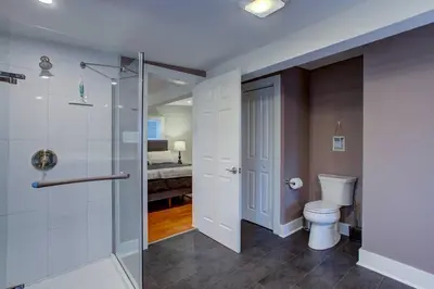 a bathroom with a toilet and a walk in shower at Calla Lily Farmhouse in Manheim