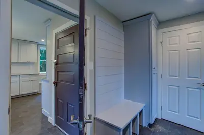 a kitchen with a door and a bench in a room at Calla Lily Farmhouse in Manheim