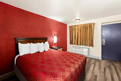 a red room with a bed with a red wall at Bellmawr Economy Inn Bellmawr-Philadelphia Area in Bellmawr