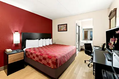 a hotel room with a bed and a desk at Bellmawr Economy Inn Bellmawr-Philadelphia Area in Bellmawr