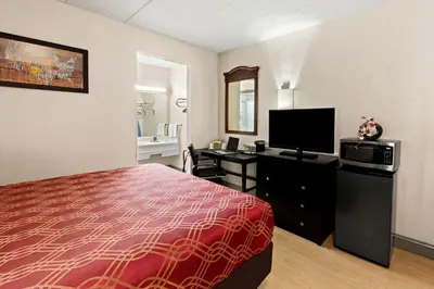 a hotel room with a bed and a flat screen tv at Bellmawr Economy Inn Bellmawr-Philadelphia Area in Bellmawr
