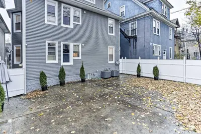 a blue house with trees in front of it at Pet-Friendly Newark Townhome Near Airport! in Newark