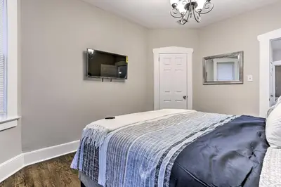 a bedroom with a bed and a flat screen tv at Pet-Friendly Newark Townhome Near Airport! in Newark