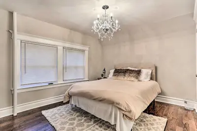 a bedroom with a bed and a chandelier at Pet-Friendly Newark Townhome Near Airport! in Newark