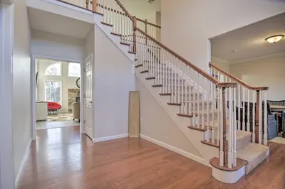 a staircase in a home with white walls and wood floors at Pool and Furnished Patio Group Getaway in Hershey in Hershey