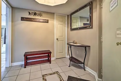 a hallway with a table and a stool and a mirror at Steps to Shore Scenic Big Boulder Lake Condo! in Lake Harmony